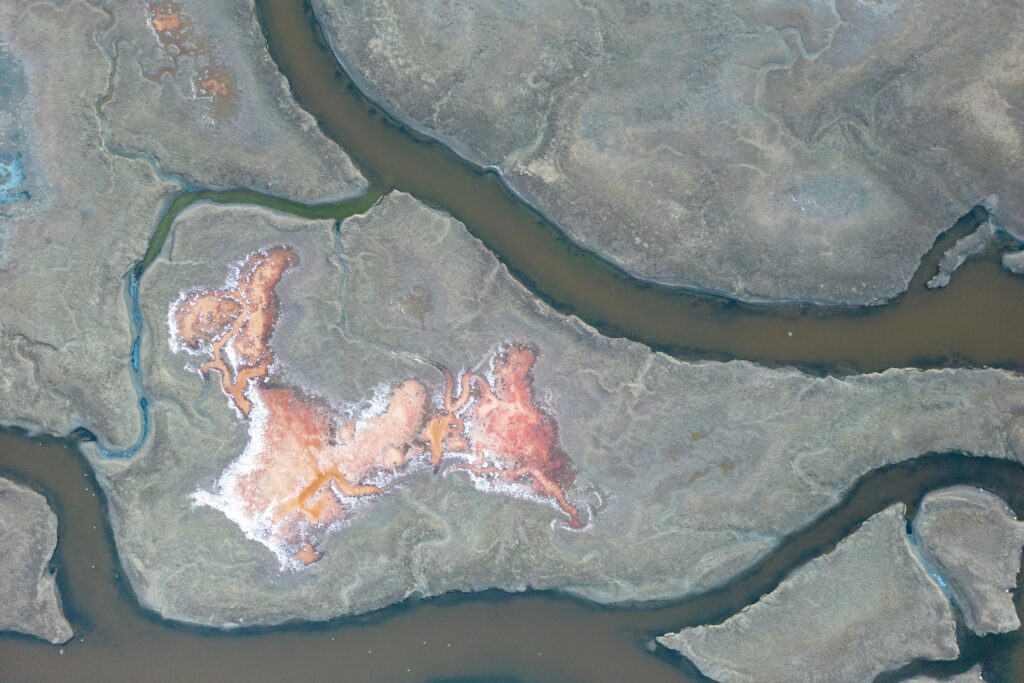 Stunning aerial shot of salt ponds creating abstract, colorful patterns in a natural landscape.