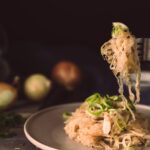 A mouthwatering plate of sauerkraut garnished with green onions, ready to eat.