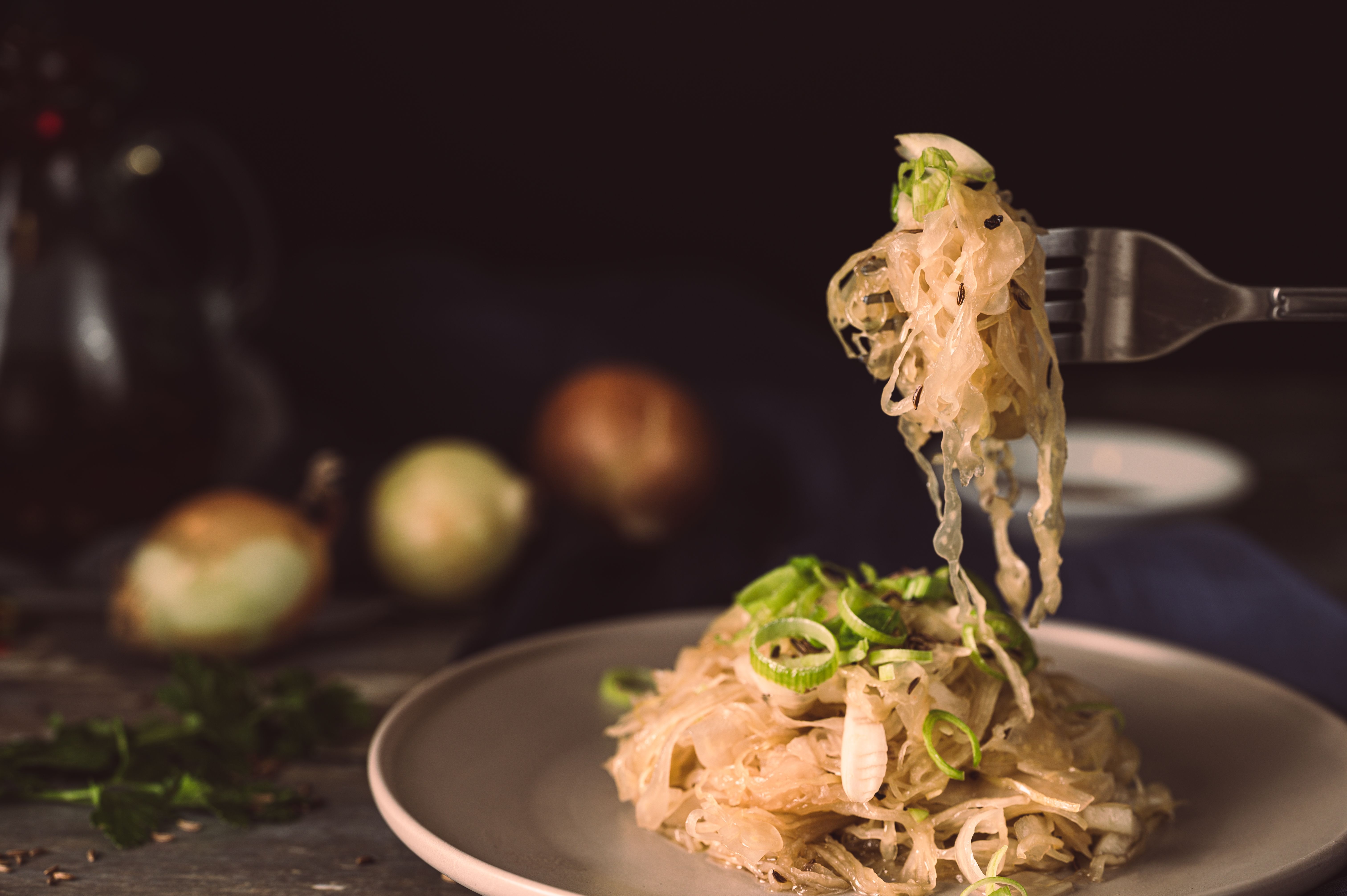 A mouthwatering plate of sauerkraut garnished with green onions, ready to eat.